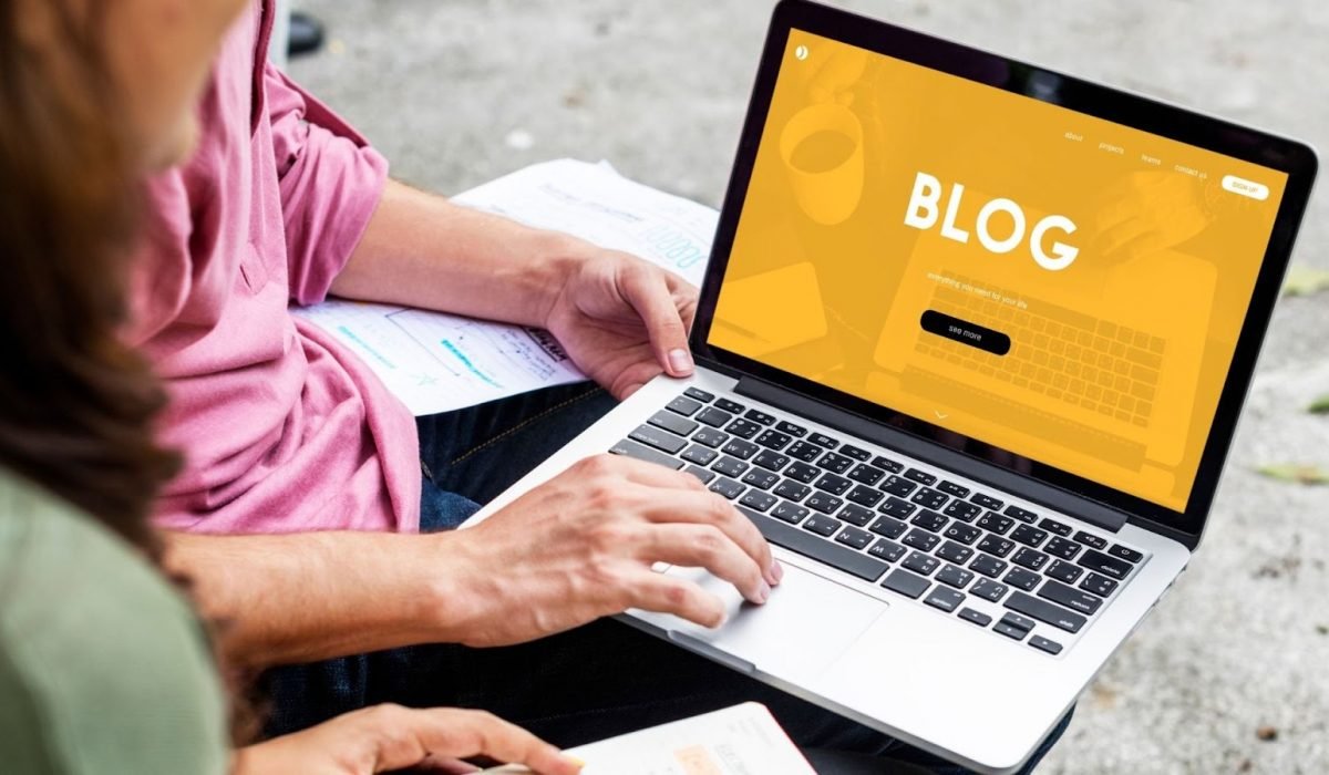 Featured image for why a blog section is essential for websites. Top view of laptop with a display of the word blog.